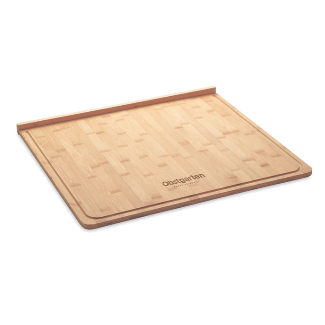 Kitchen gadget with logo KEA BOARD Large bamboo cutting board with groove. Size 38x45x1 cm. This natural looking cutting board will look great in any kitchen and is ideal for meal preparation. Whether you cook with meat or vegetables only, you can cut it all on this large board. This board fits right on the edge of your table or counter top so it will stay in place better. Bamboo is a natural product, there may be slight variations in colour and size per item, which can affect the final decoration outcome. Magnus Business Gifts is your partner for merchandising, gadgets or unique business gifts since 1967. Certified with Ecovadis gold 2022!