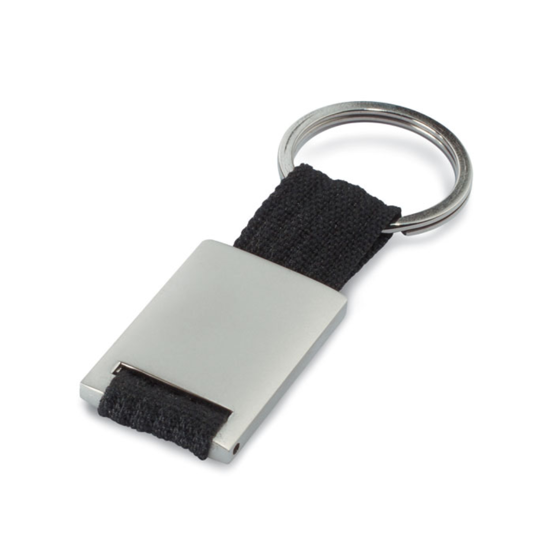 Gadget with logo Key ring TECH Metal rectangular key ring with logo with coloured polyester webbing. Individually packed in a carton gift box. Available color: Red, Blue, Black Dimensions: 9X3,5X0,8 CM Width: 3.5 cm Length: 9 cm Height: 0.8 cm Volume: 0.11 cdm3 Gross Weight: 0.034 kg Net Weight: 0.026 kg Magnus Business Gifts is your partner for merchandising, gadgets or unique business gifts since 1967. Certified with Ecovadis gold!
