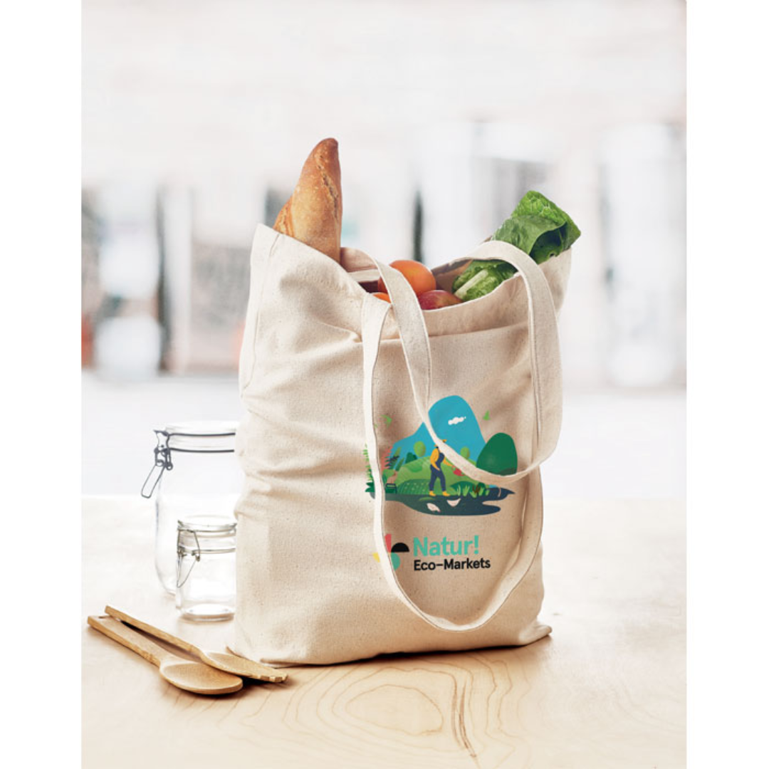 Gadget with logo Totebag RASSA Canvas shopping bag with logo with long handles and with bottom gusset. An ideal bag for your daily grocery shopping. The long handles make it easy to carry it by either holding it or hanging it over your shoulder. This canvas tote has a base gusset so you can carry more items than with a regular shaped bag. 270 gr/m². Produced under a certified standard for the use of harmful substances in textile. Available color: Beige Dimensions: 38X9X42 CM Width: 9 cm Length: 38 cm Height: 42 cm Volume: 0.722 cdm3 Gross Weight: 0.164 kg Net Weight: 0.149 kg Magnus Business Gifts is your partner for merchandising, gadgets or unique business gifts since 1967. Certified with Ecovadis gold!