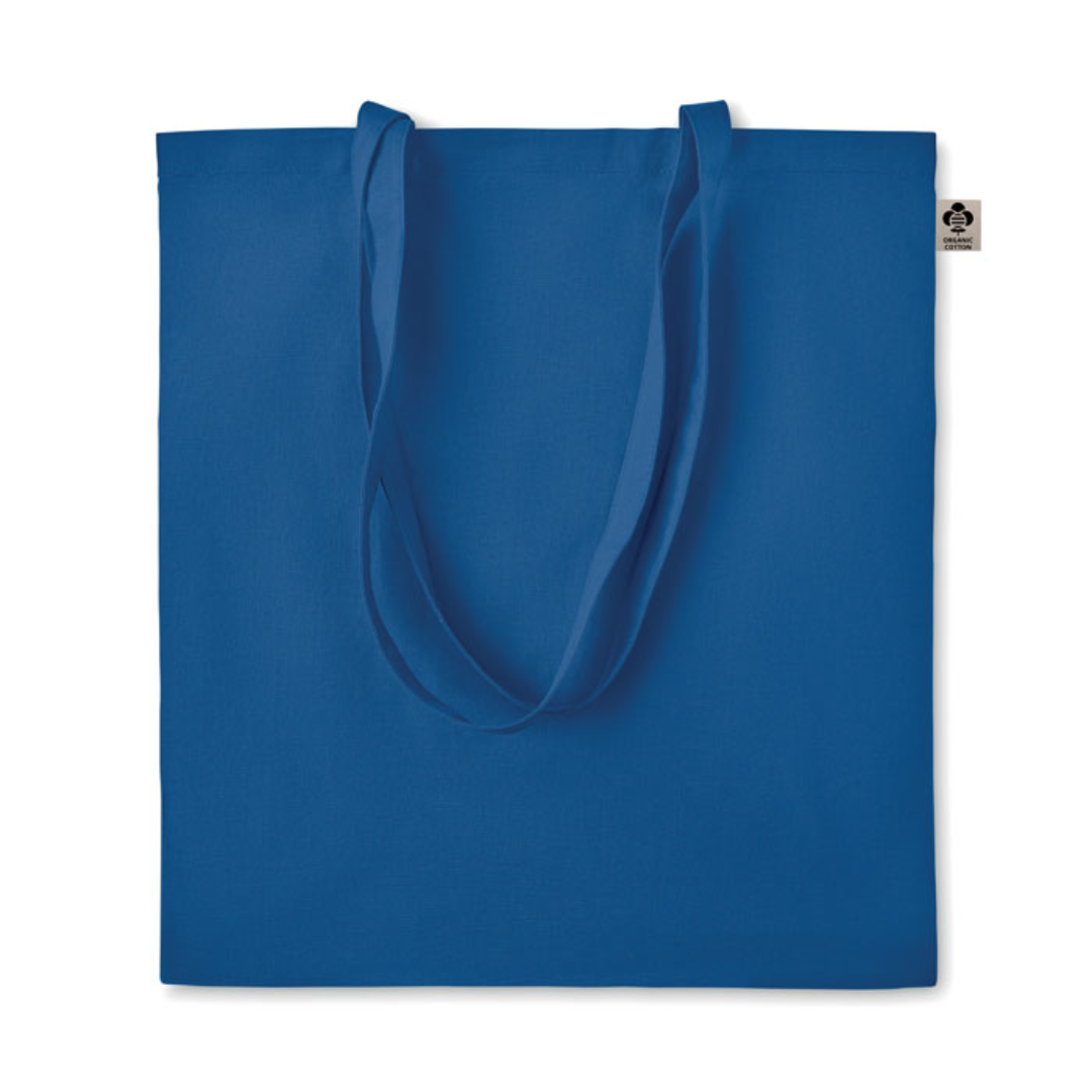 Gadget with logo Bag ZIMDE COLOUR Certified organic cotton shopping bag with logo with long handles. Made from 100% natural organic cotton 140 gr/m². A classic tote bag design made to carry your daily groceries or other items. Carry the bag in your hands or over your shoulder with the long handles. Available color: Orange, Red, Green, Baby Blue, Royal Blue, Blue, White, Dark Grey Magnus Business Gifts is your partner for merchandising, gadgets or unique business gifts since 1967. Certified with Ecovadis gold!