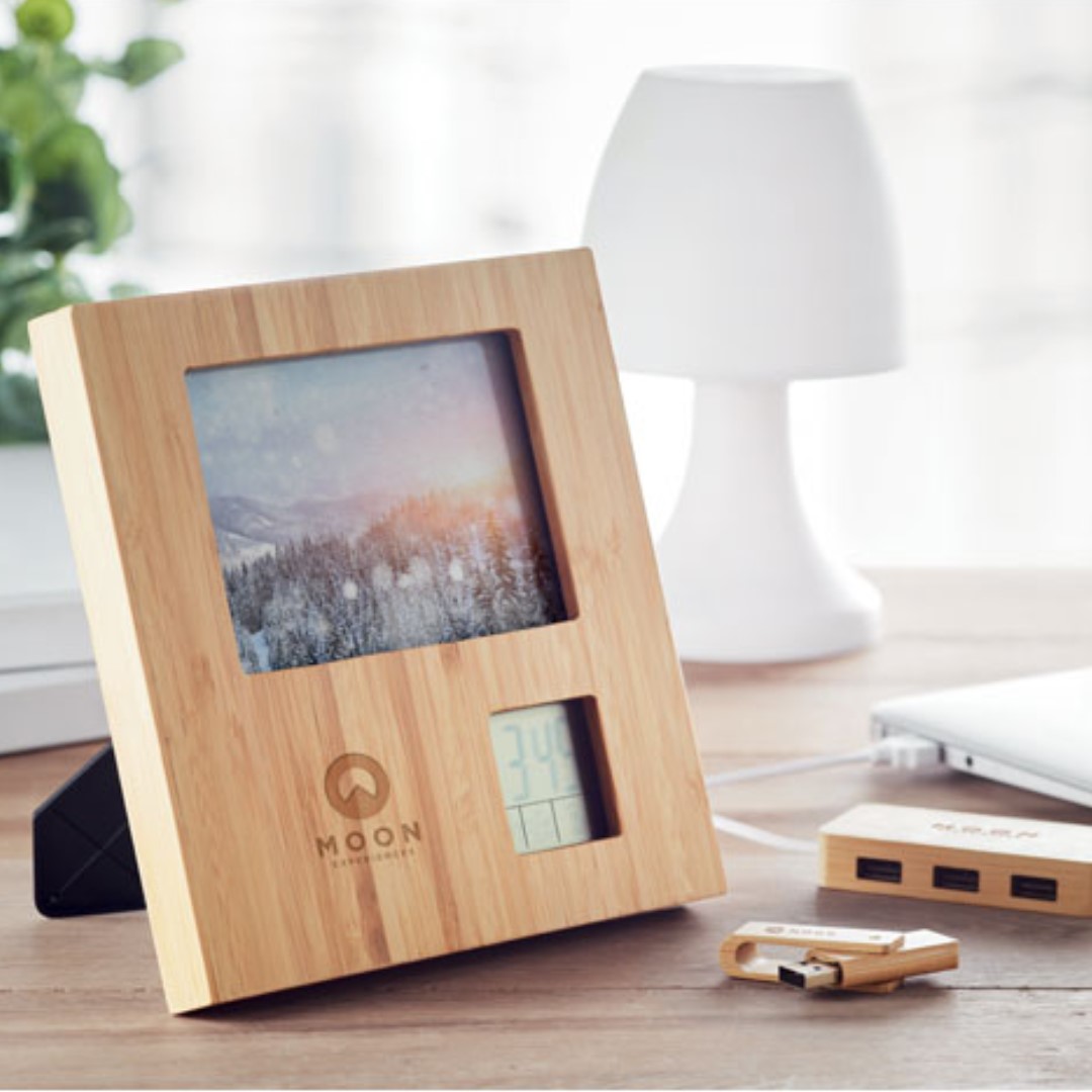 Gadget with logo Photo frame weather station ZENFRAME Gadget with logo Photo frame in bamboo with weather station. Displays time, date and temperature. Alarm function and count down timer. 2 AAA batteries not included. Available color: Wood Bamboo is a natural product, there may be slight variations in color and size per item. Dimensions: 18,5X18,5X2 CM Width: 18.5 cm Length: 18.5 cm Height: 2 cm Volume: 1.671 cdm3 Gross Weight: 0.377 kg Net Weight: 0.293 kg Depending on the surface we can use embroidery, engraving, 360° imprint or screen print.