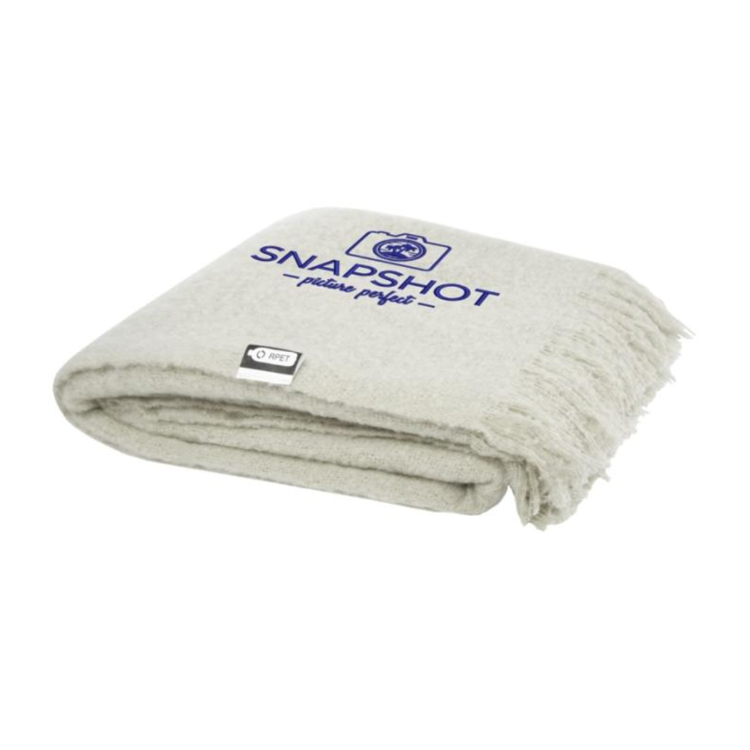 Gadget with logo PLAID blanket Ivy Gadget with logo Ultra-soft RPET mohair plaid, wrapped with a 190T RPET ribbon. Packed in a recycled poly bag. Fringes length: 10 cm on each side. Ribbon size: 72 cm x 4 cm. 100% Recycled Polyester, 215 g/m2, 190T of 100% Recycled Polyester. Available colors: Beige, Light Grey Depending on the surface we can use embroidery, engraving, 360° imprint or screen print.
