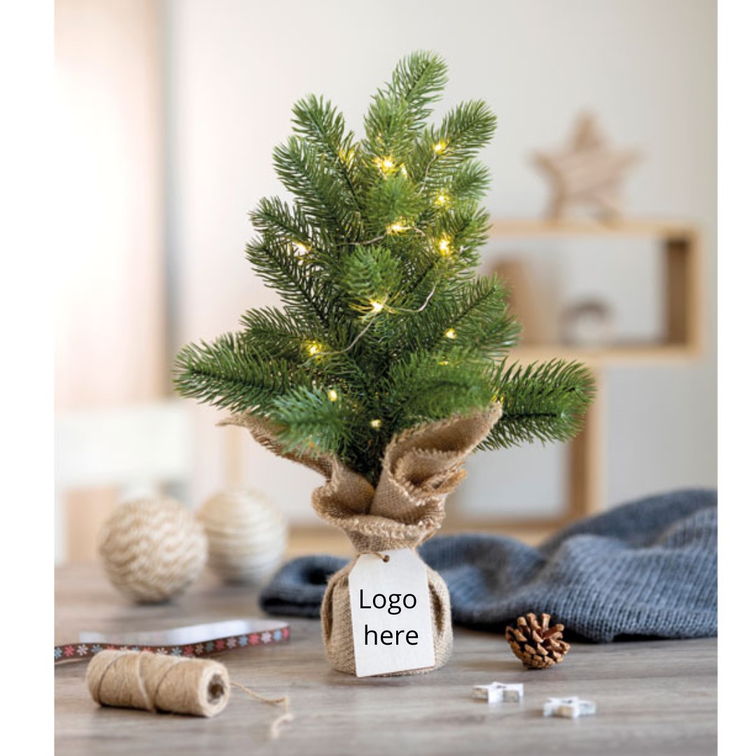 Mini Christmas tree with logo AVETO Mini artificial (PE) Christmas tree with 20 LED warm yellow string lights on a jute base. Comes with a wooden gift tag. 2 AA batteries excluded. Magnus Business Gifts is your partner for merchandising, gadgets or unique business gifts since 1967. Certified with Ecovadis gold!